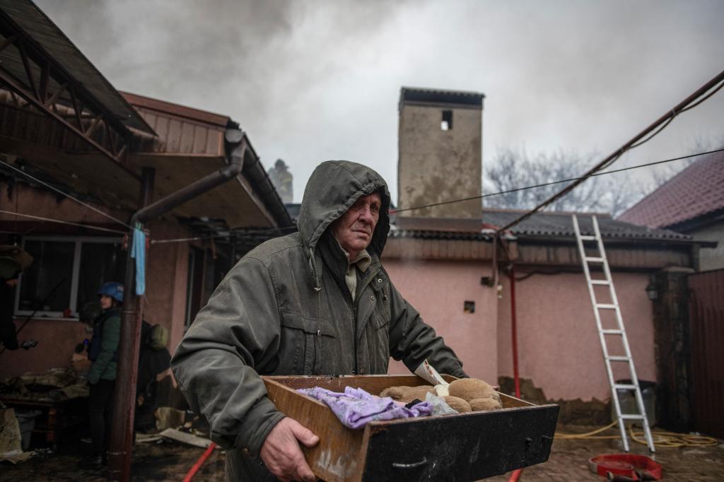 A local resident carries belongings outside a damaged house hit by recent shelling in the course of Russia-Ukraine conflict in Donetsk, Russian-controlled Ukraine, November 30, 2023.