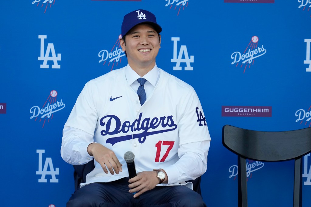 odgers' Shohei Ohtani smiles during a baseball news conference at Dodger Stadium