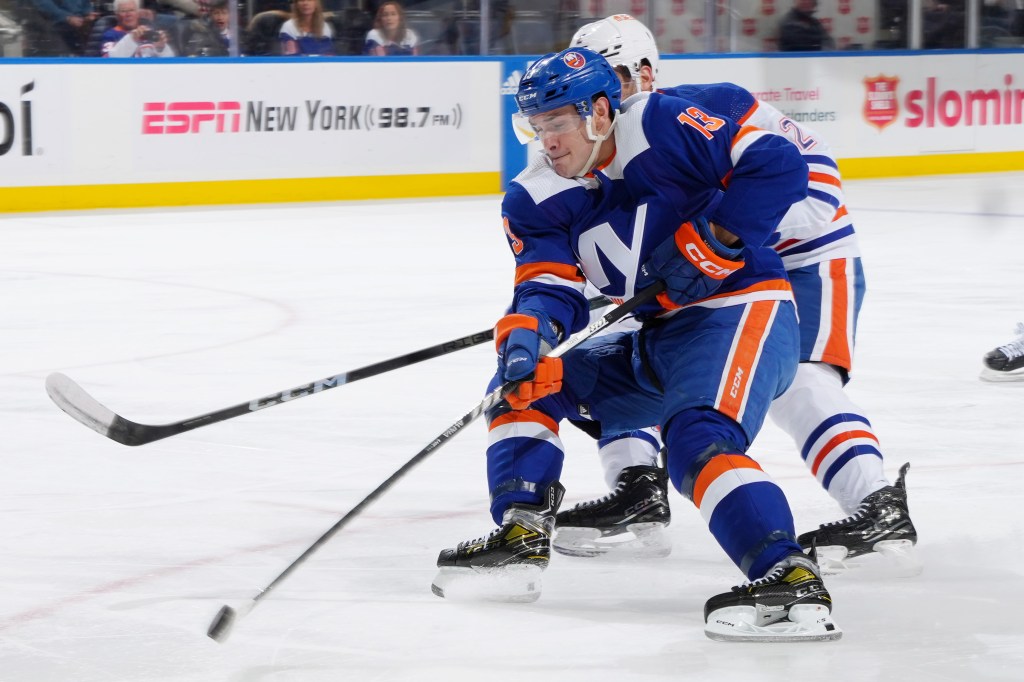 Mathew Barzal #13 of the New York Islanders controls puck against Evan Bouchard #2 of the Edmonton Oilers