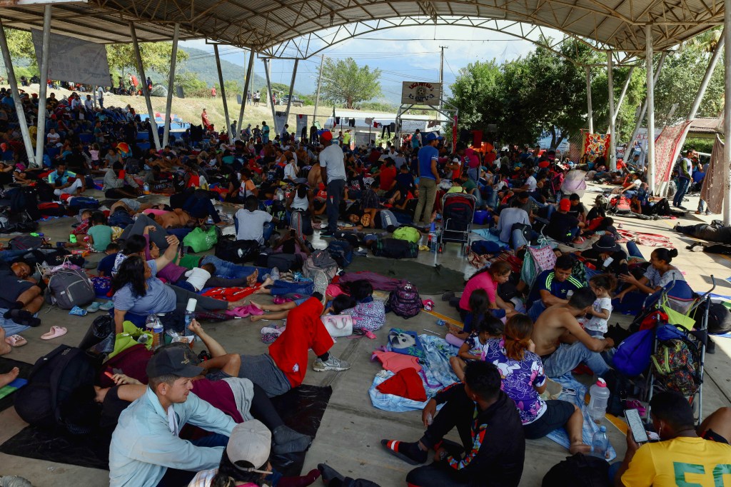 Migrants traveling in a caravan rest in a public square before continuing their journey through Mexico.