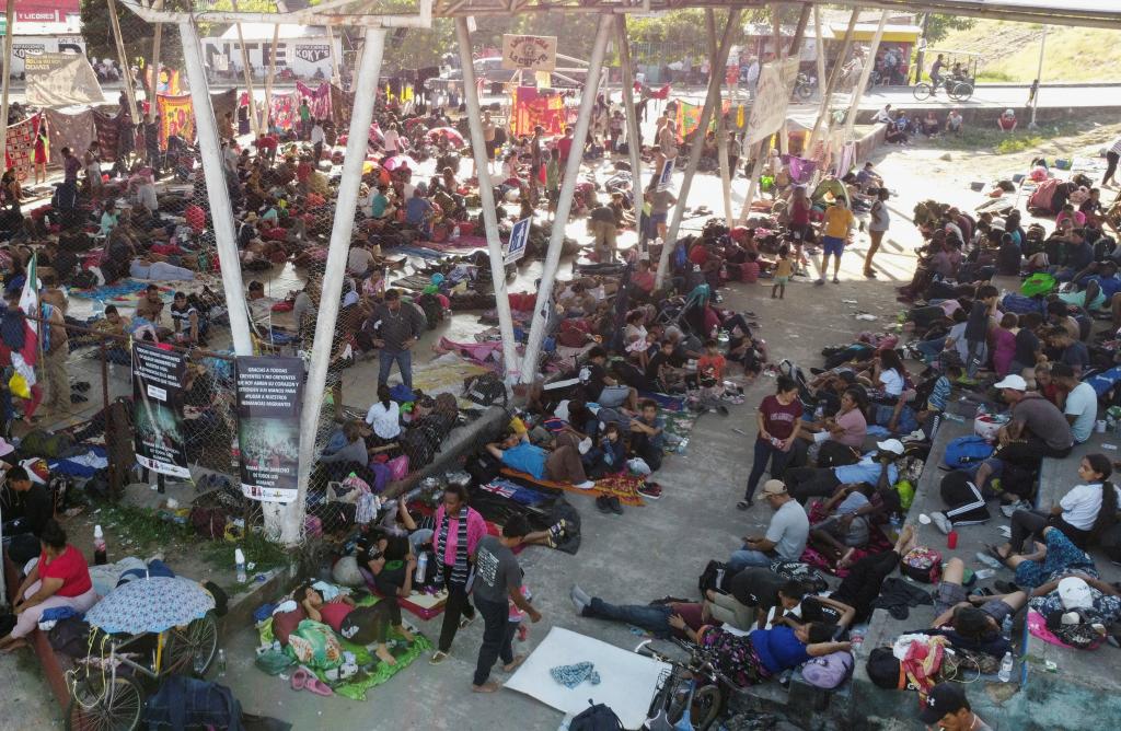 Migrants traveling in a caravan rest in a public square before continuing their journey through Mexico.