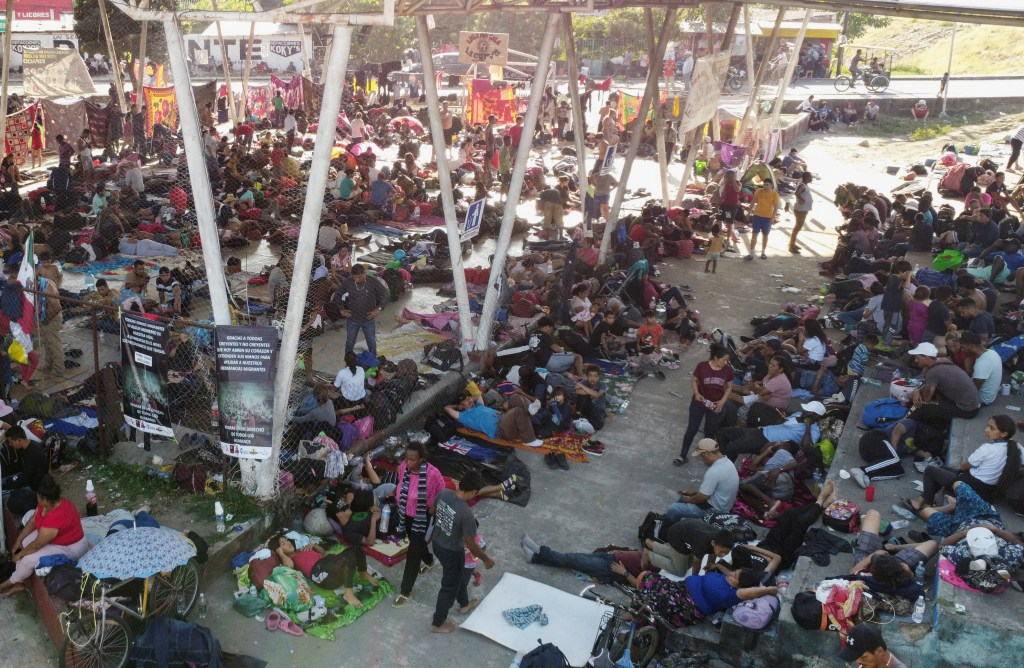 Migrants traveling in a caravan rest in a public square before continuing their journey through Mexico.