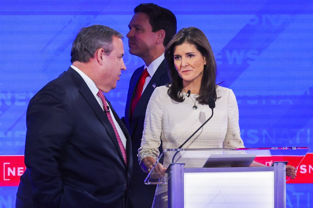 Republican presidential candidate and former New Jersey Governor Chris Christie speaks to Republican presidential candidate and former U.S. Ambassador to the United Nations Nikki Haley as Republican presidential candidate Florida Governor Ron DeSantis passes by, during a break, at the fourth Republican candidates' U.S. presidential debate of the 2024 U.S. presidential campaign at the University of Alabama in Tuscaloosa, Alabama