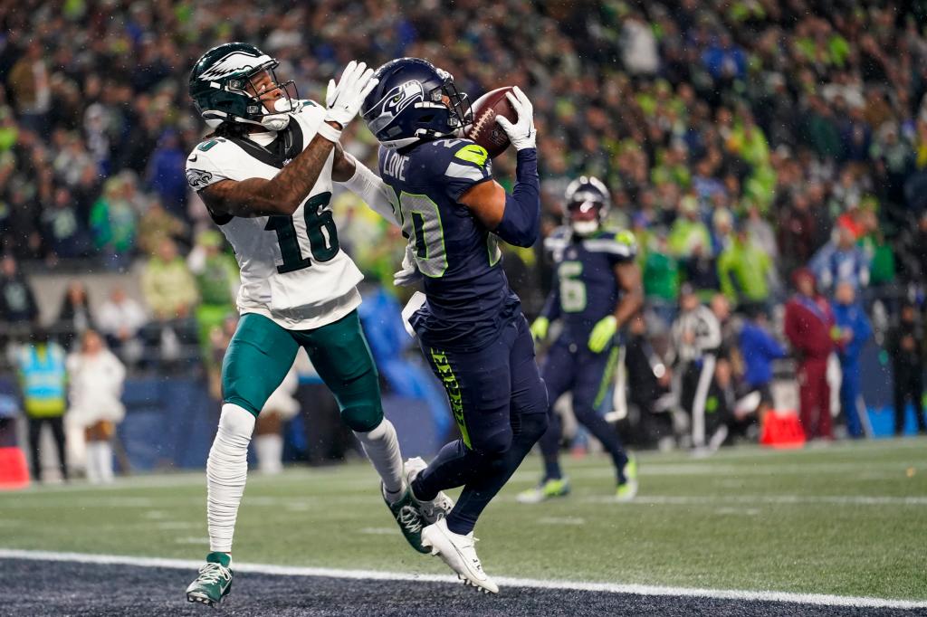 Julian Love, right, prepares to make an interception on a pass intended for Philadelphia Eagles wide receiver Quez Watkins (16).