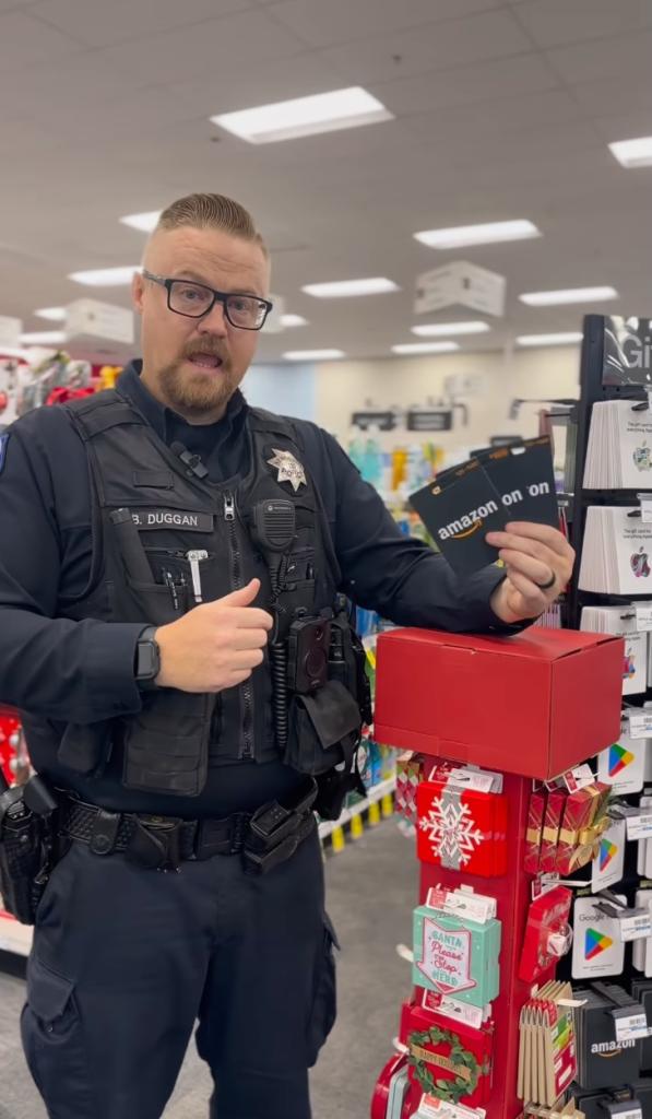 Police officer holds up Amazon gift cards