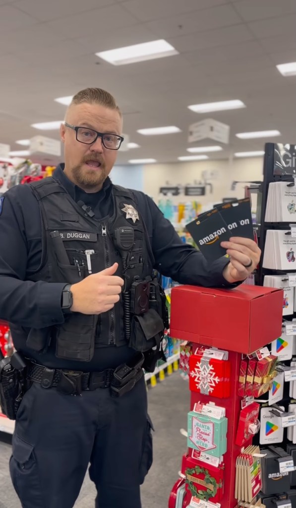 Police officer holds up Amazon gift cards