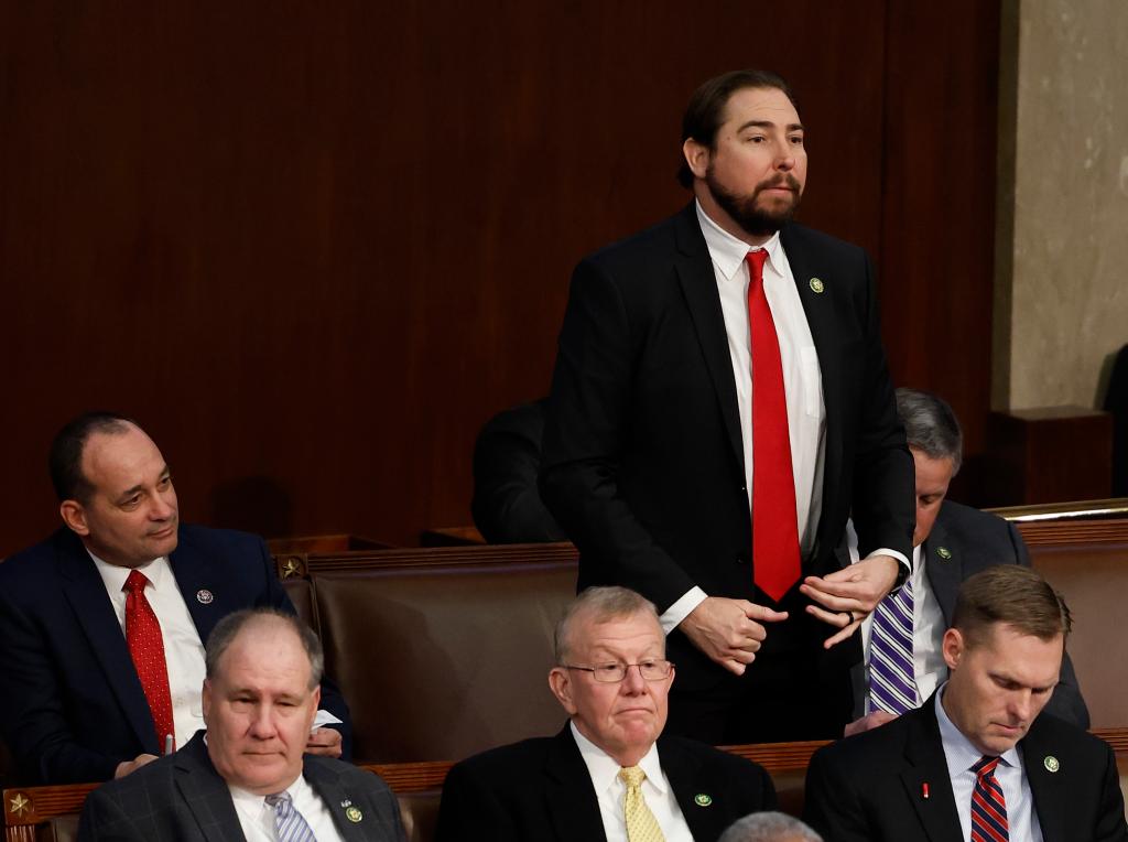 Rep. Eli Crane on his feet speaking in the House surrounded by other Republican men in suits 
