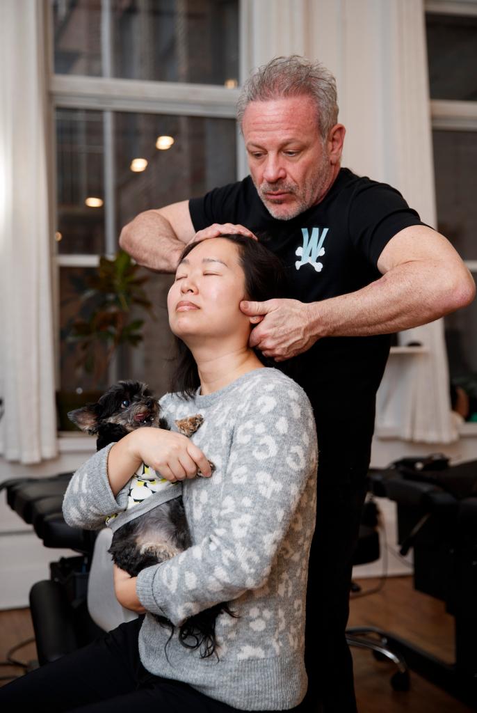 Chiropractor Doug Willen, 59, in his Fifth Avenue offices with patients Christie Park and her 12-year-old Yorkipoo, Rookie.
