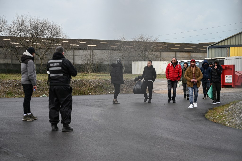 Migrants who survived a shipwreck leave a reception center in the city of Calais, northen France, on January 14, 2024. 