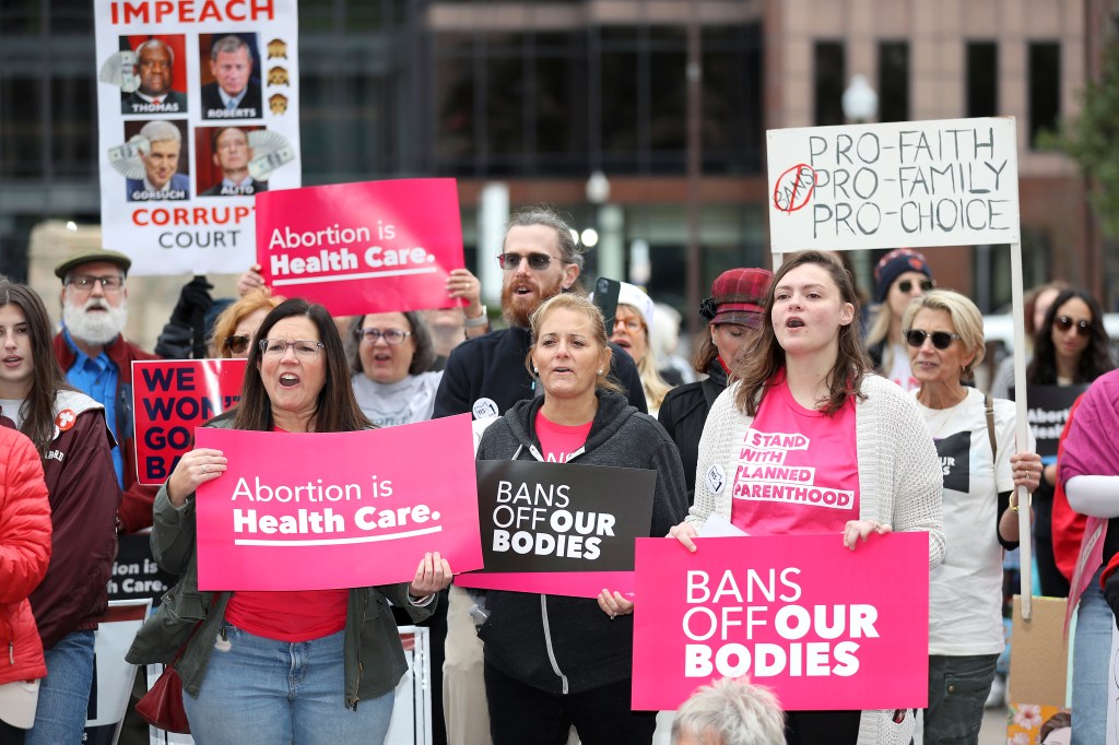 Supporters of Issue 1, the Right to Reproductive Freedom amendment, holding signs at a rally at the Ohio Statehouse in Columbus, Ohio
