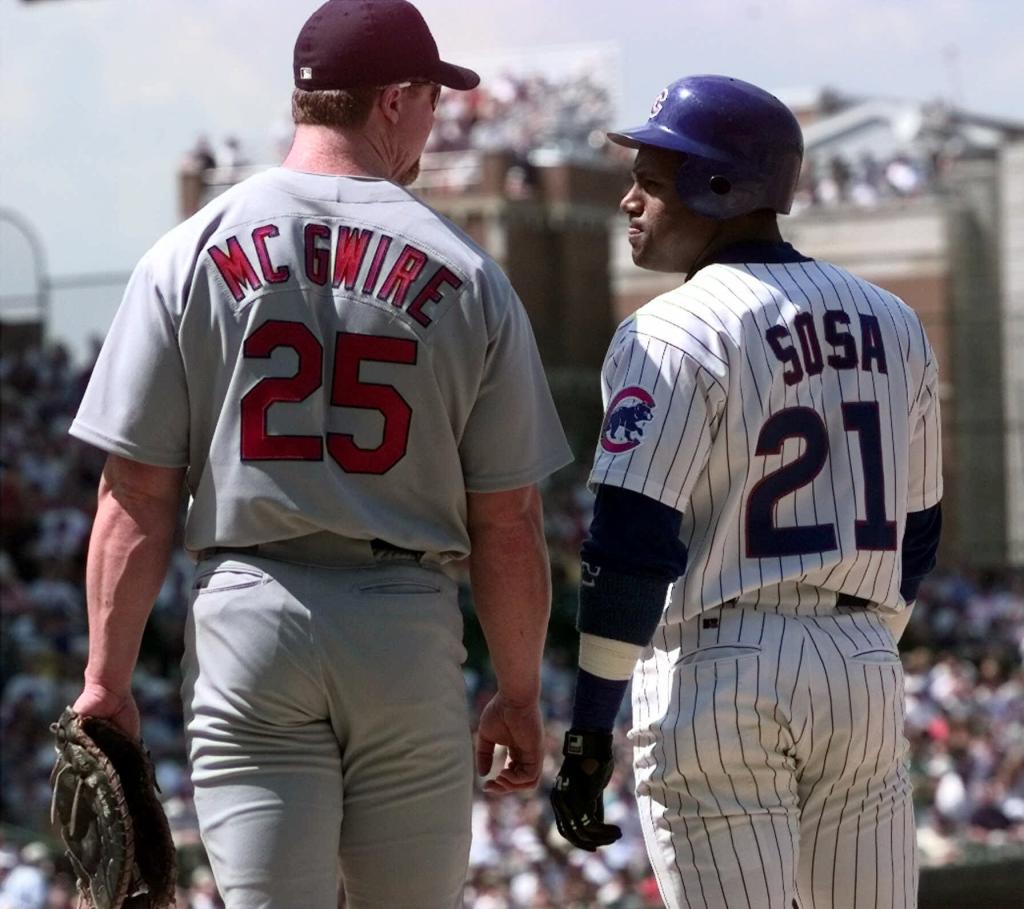 Chicago Cubs' Sammy Sosa, right,  and St. Louis Cardinals' Mark McGwire (25) chat at first base after Sosa singled in the second inning of a baseball game at Wrigley Field in Chicago. 