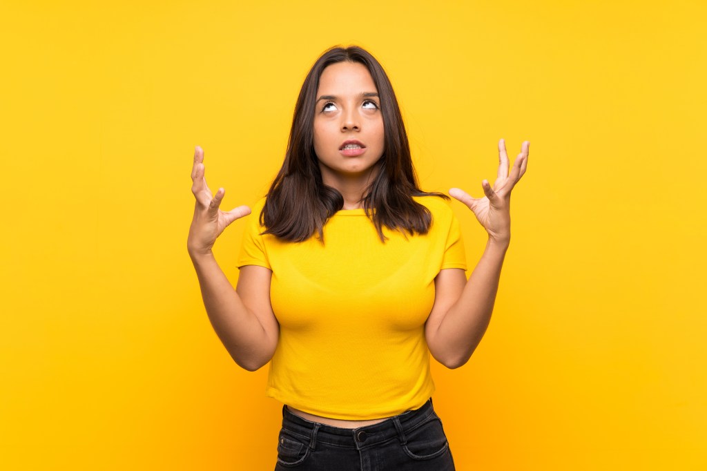 Young brunette girl over isolated background frustrated by a bad situation