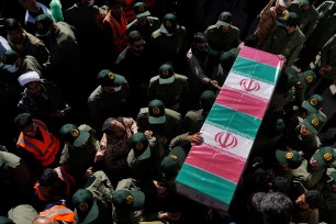 Revolutionary Guard members carry the flag-draped coffin of a victim of Wednesday's bomb explosion, during the victims funeral ceremony in the city of Kerman about 510 miles (820 kms) southeast of the capital Tehran, Iran, Friday, Jan. 5, 2024