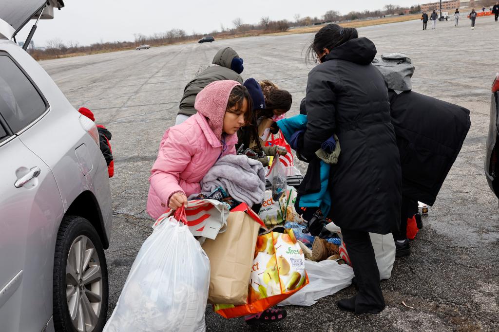 Migrants receive donated clothes from other individuals who come by and donate food and clothing. 