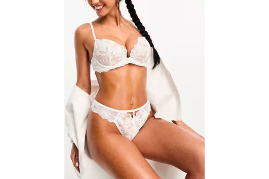 A woman in a bridal white lace push up bra and lace panties