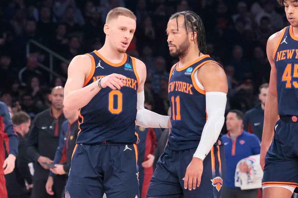 New York Knicks guard Donte DiVincenzo #0 speaks with New York Knicks guard Jalen Brunson #11 on the court during the first quarter.