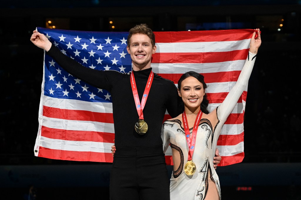 Gold medallists USA's Madison Chock (R) and Evan Bates pose with the country's national flag during the medal ceremony for ice dance free skating event during the ISU Grand Prix of Figure Skating Final in Beijing on December 9, 2023