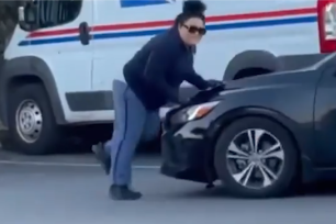 video shows the dedicated uniformed US Postal Service worker blocking the way of the fleeing bandits’ black getaway car with her body.