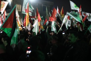 Members of the Popular Mobilization Forces carry flags during the funeral procession of two Iran-backed militiamen killed in a US airstrike in Iraq.