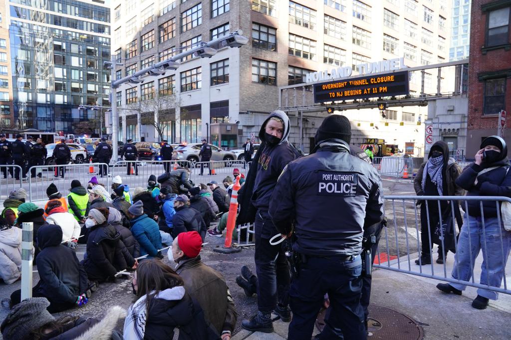 Cops stand over arrested protesters by the Holland Tunnel entrance in NYC.