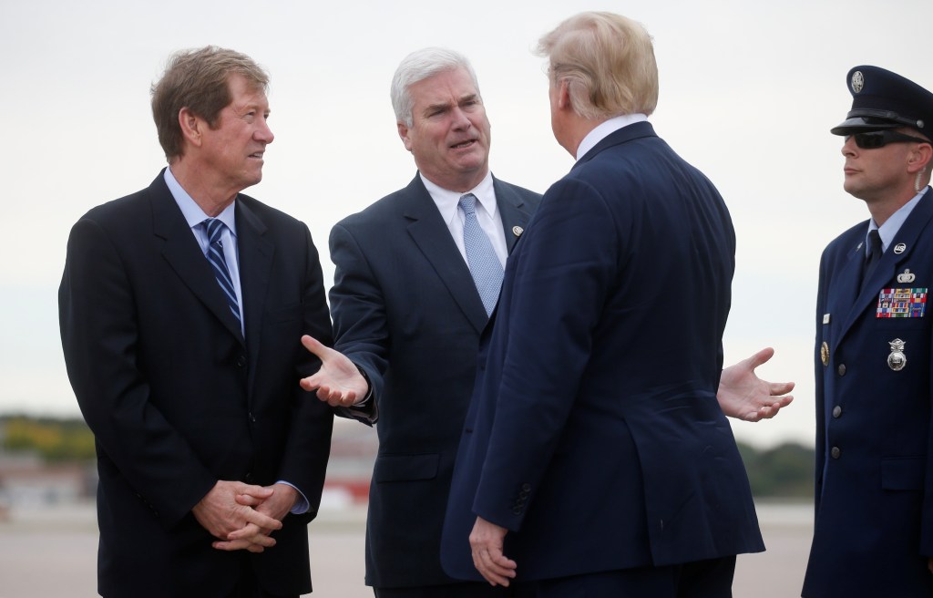 President Donald Trump talks with U.S. Rep Jason Lewis (L) and Rep. Tom Emmer (C) as he arrives at Minneapolis Ã¢â¬â Saint Paul International Airport for nearby fundraising and campaigning in Minneapolis, Minnesota, U.S. October 4, 2018.