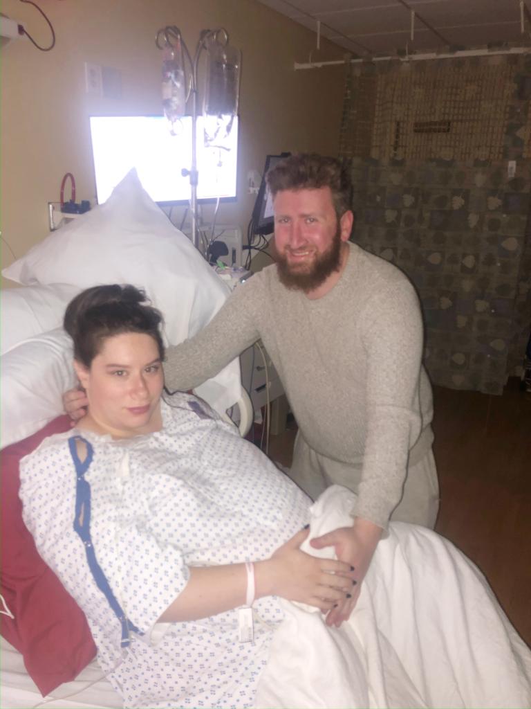 a man standing next to a woman in a hospital bed
