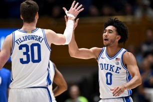 Jared McCain #0 high-fives Kyle Filipowski #30 of the Duke Blue Devils.