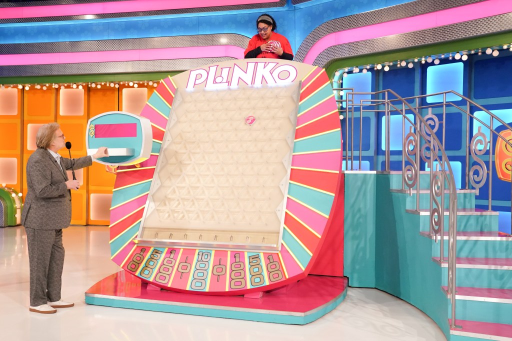 Drew Carey watches as a contestant drops her chips into the Plinko game hoping to win $10,000 on "The Price Is Right."