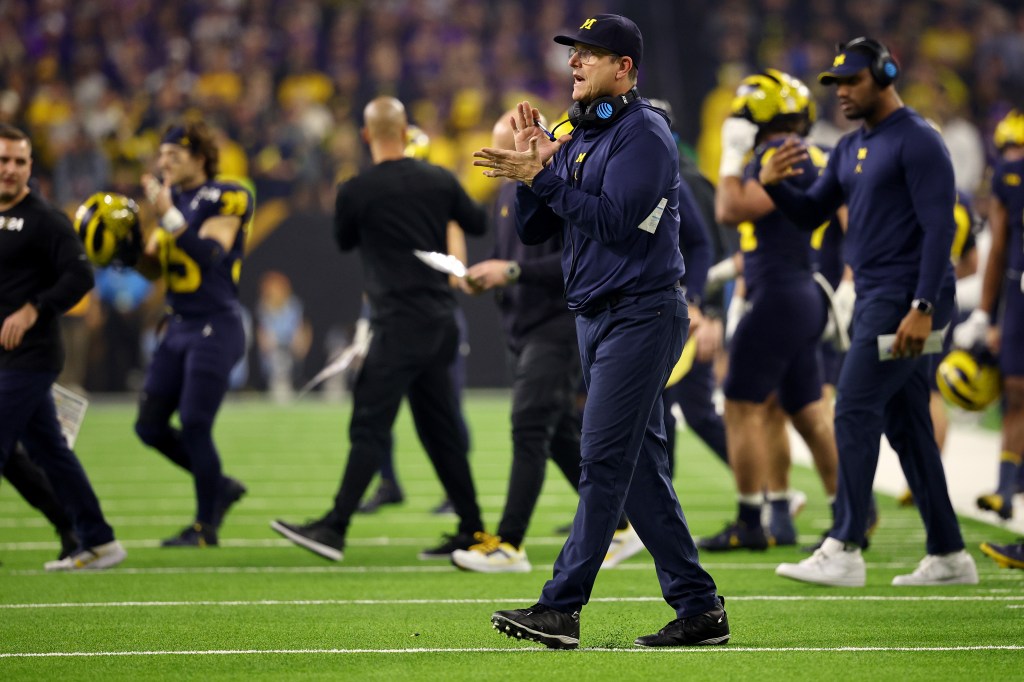 Head coach Jim Harbaugh of the Michigan Wolverines applauds his players against the Washington Huskies during the 2024 CFP National Championship game.