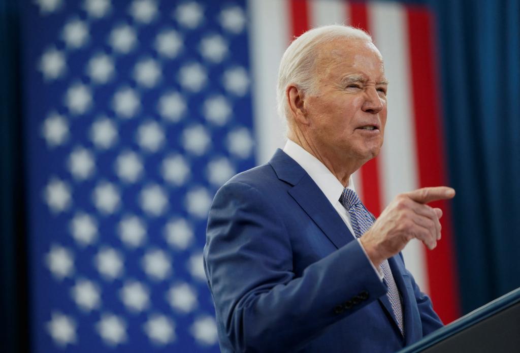 Joe Biden giving a speech in front of an American flag