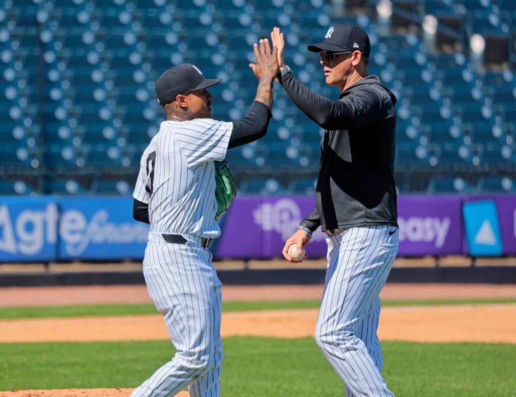 Marcus Stroman (L.) high-fives Aaron Boone at Yankees spring training on Feb. 19, 2024. 