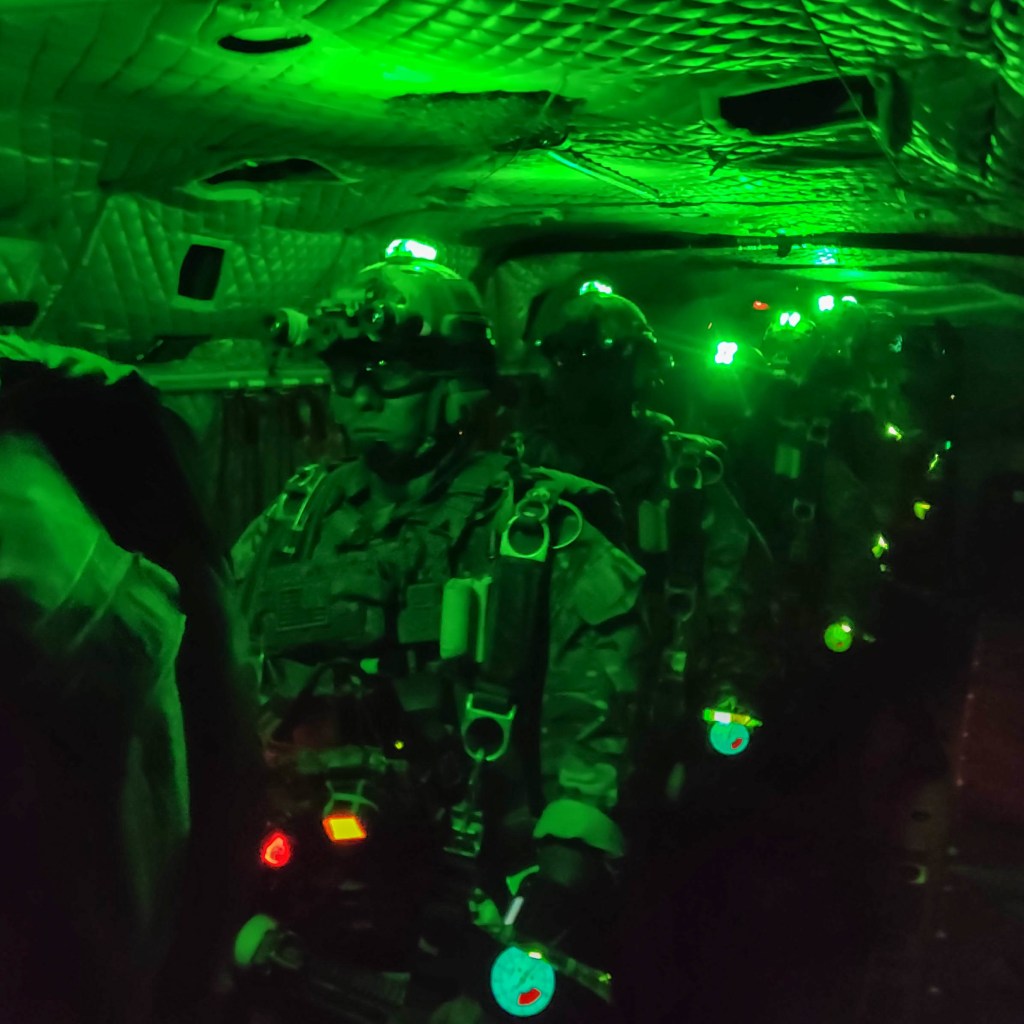 Green Beret special ops prepare for a nighttime free fall jump, as seen with green night vision. 