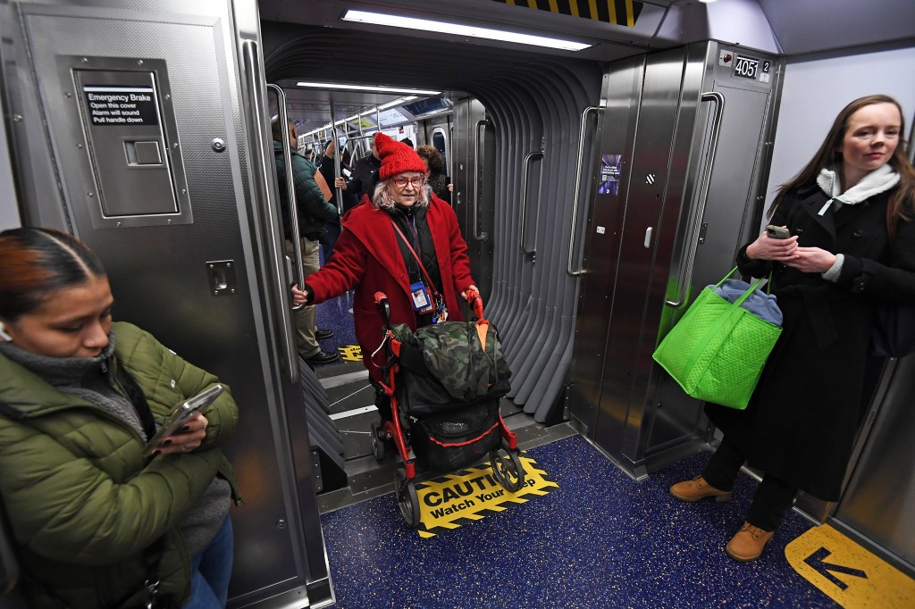 A woman stands near the wider doorways on the open gangway