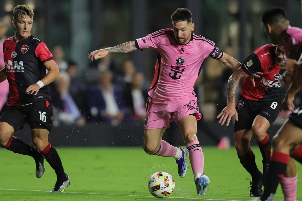 Inter Miami CF forward Lionel Messi (10) dribbles the ball past Newell's Old Boys defender Pablo Perez (8) during the first half at DRV PNK Stadium on Feb. 15.