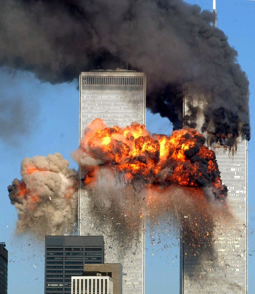 Twin towers on 9/11. One is smoking, the other has a fireball coming out of it. 