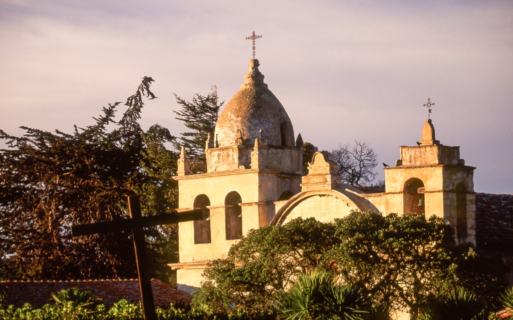 The dome shaped bell and square bell towers crown the facade of historic Old Mission San Carlos Borromeo, second of nine missions established by Fr. Junipero Serra in 1770, and site of his tomb, is located in Carmel Valley on the Monterey Peninsula in Northern California.
