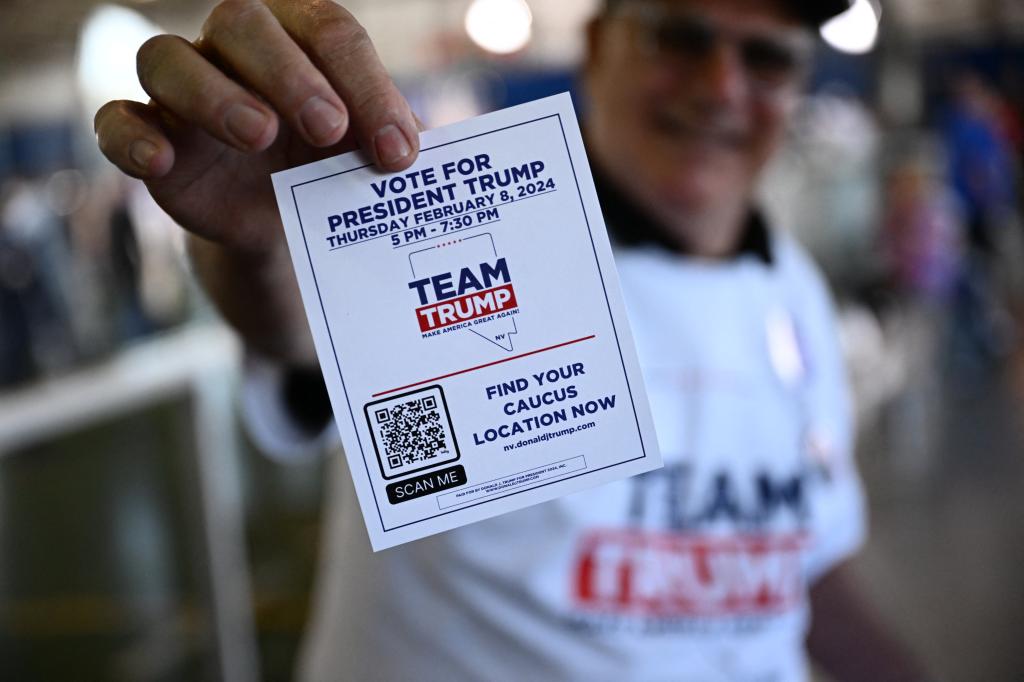 A man holding a card with voting information at a Commit to Caucus Rally for Donald Trump in Las Vegas, Nevada in January 2024.