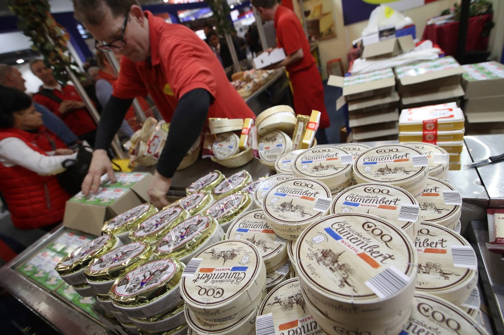 BERLIN, GERMANY - JANUARY 19:  A stand host sells different kinds of French cheese, including camembert, at the 2018 International Green Week (Internationale Gruene Woche) agricultural trade fair on January 19, 2018 in Berlin, Germany. The International Green Week is among the world's biggest agricultural trade fairs and brings together agriculture, food, nutrition and horticulture. It is open to the public from January 19-28.  (Photo by Sean Gallup/Getty Images)