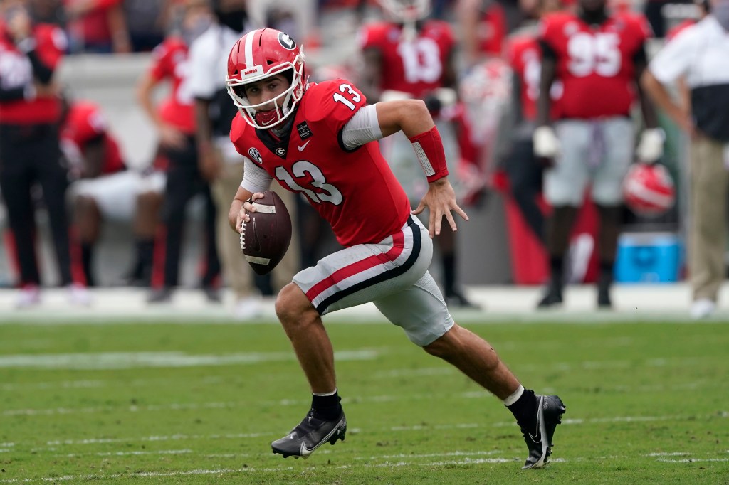 Georgia quarterback Stetson Bennett scrambles with a football against Tennessee in an NCAA college football game in Athens, Georgia.