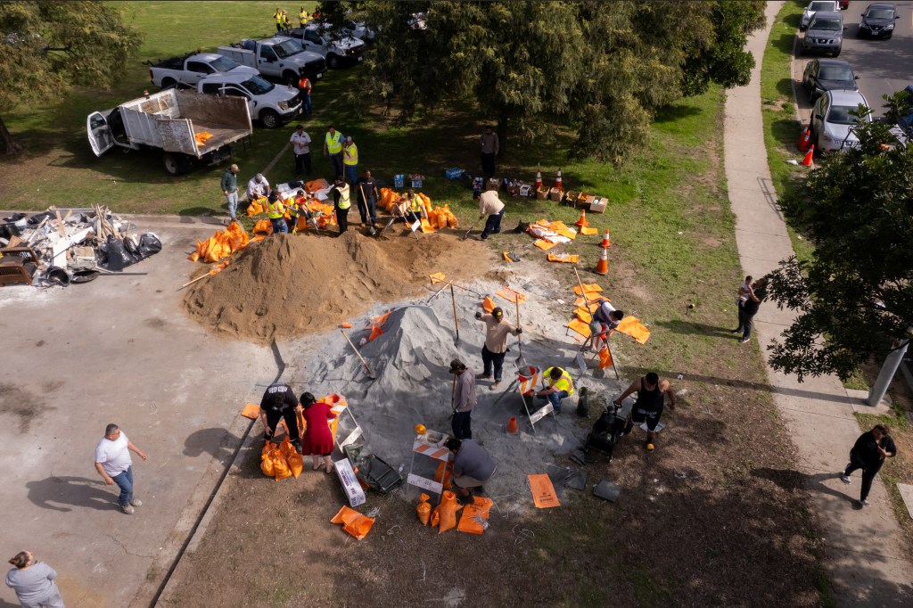 Local residents and volunteers of the recently flooded Southcrest neighborhood help fill sand bags in a park as they prepare for the first of two atmospheric weather systems expected to bring heavy rain to San Diego, California, U.S. January 31, 2024.