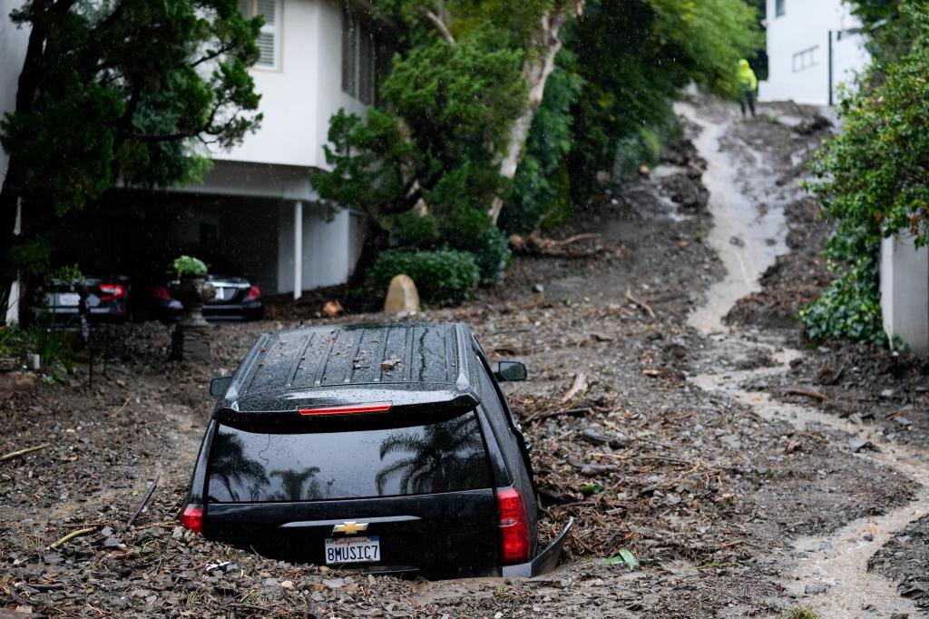 An SUV sits buried by a mudslide