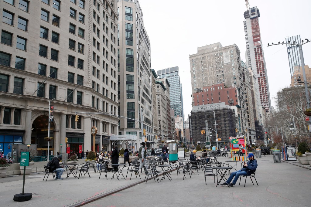 Randomly scattered tables and chairs on a sidewalk and pedestrian street