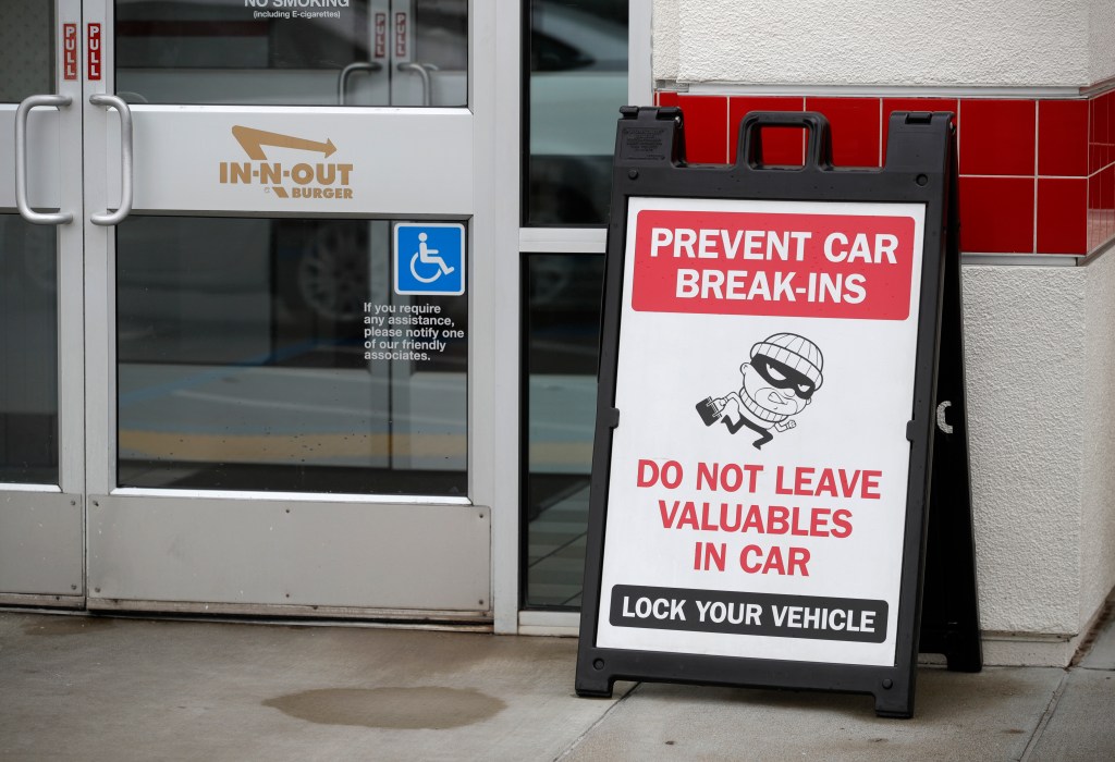 Sign warns of car break-ins at In-N-Out restaurant in Oakland. Restaurant to close due to theft and robberies.