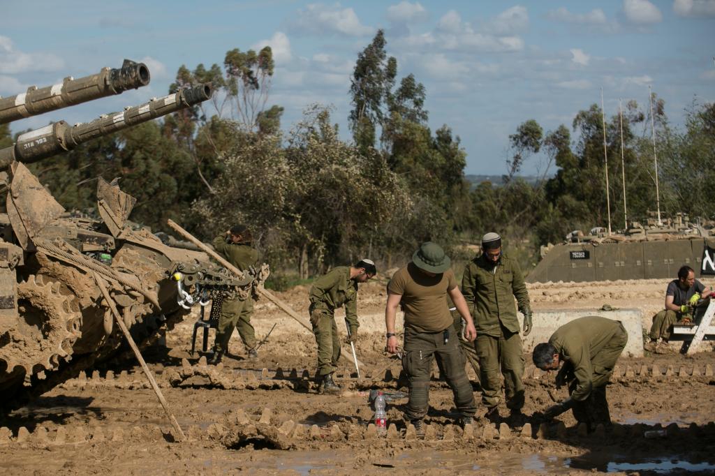 Israeli soldiers fix a tank's tracks as they continue their advancement in Gaza.