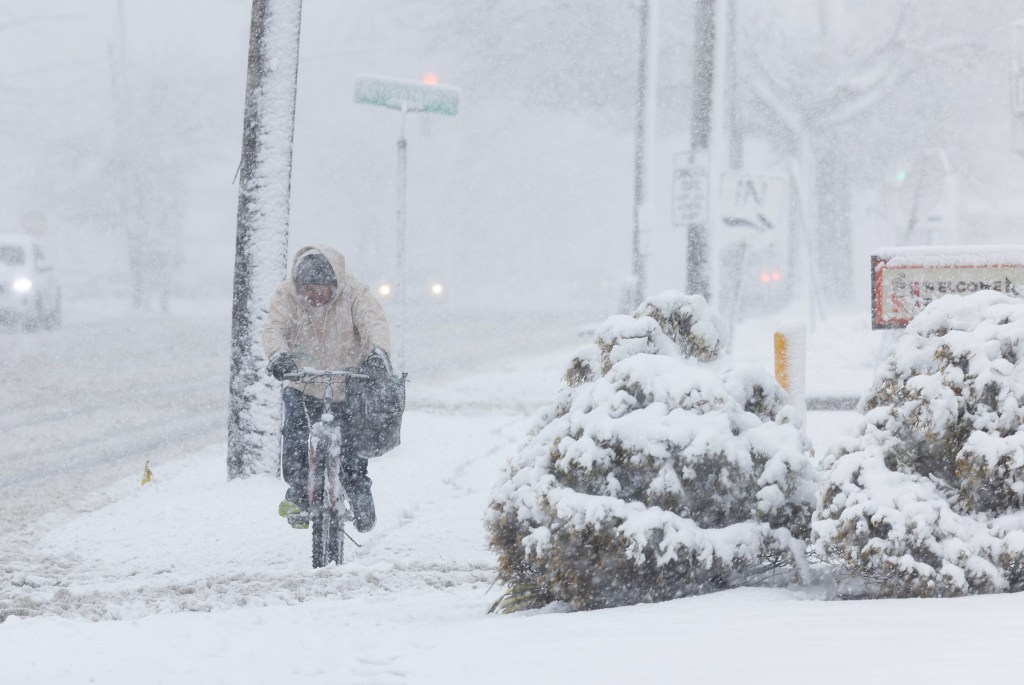 Heavy snow on special Election Day in Westbury, NY may hinder voters chances of voting. Photo: person riding a bicycle in the snow.