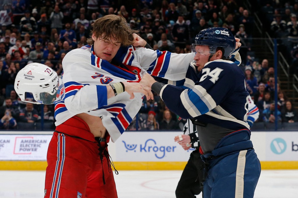 Two hockey players, Mathieu Olivier and Matt Rempe, fighting during an NHL game between the New York Rangers and Columbus Blue Jackets.