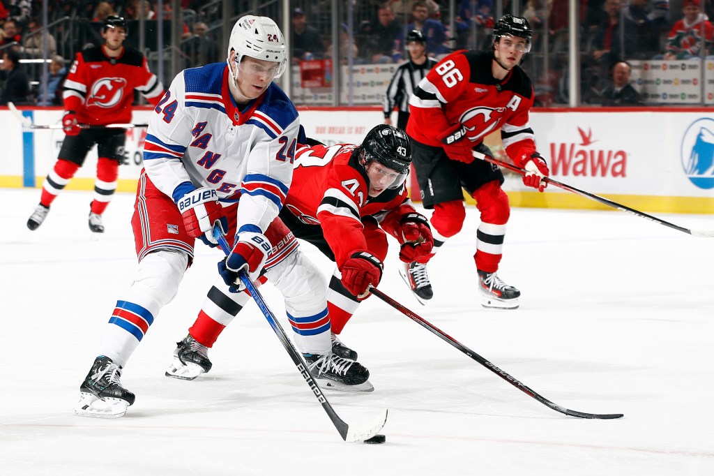 Kaapo Kakko looks to keep the puck away from Luke Hughes during the Rangers' win over the Devils last week. 