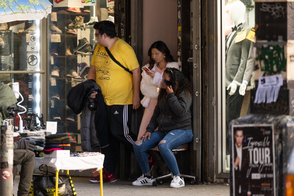 A potential customer is seen leaving a suspected brothel along Roosevelt Avenue 