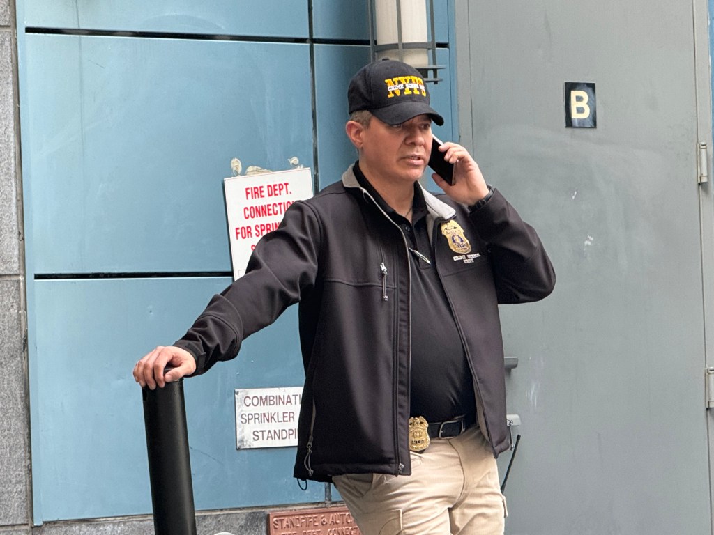 NYPD detective on the phone at the scene outside the hotel