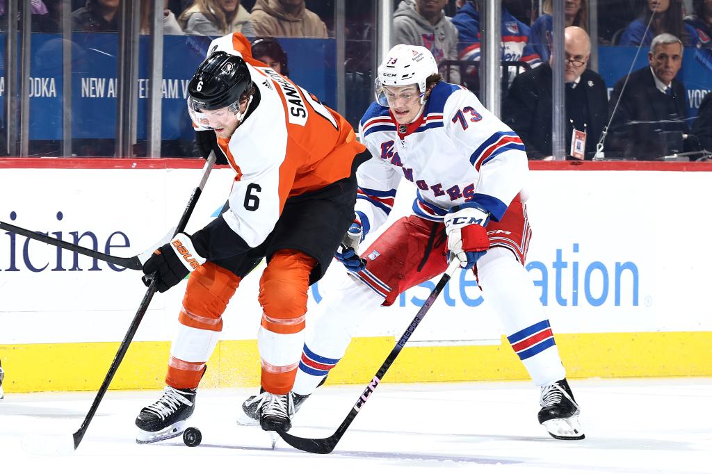 Travis Sanheim #6 of the Philadelphia Flyers and Matt Rempe #73 of the New York Rangers challenge for the puck